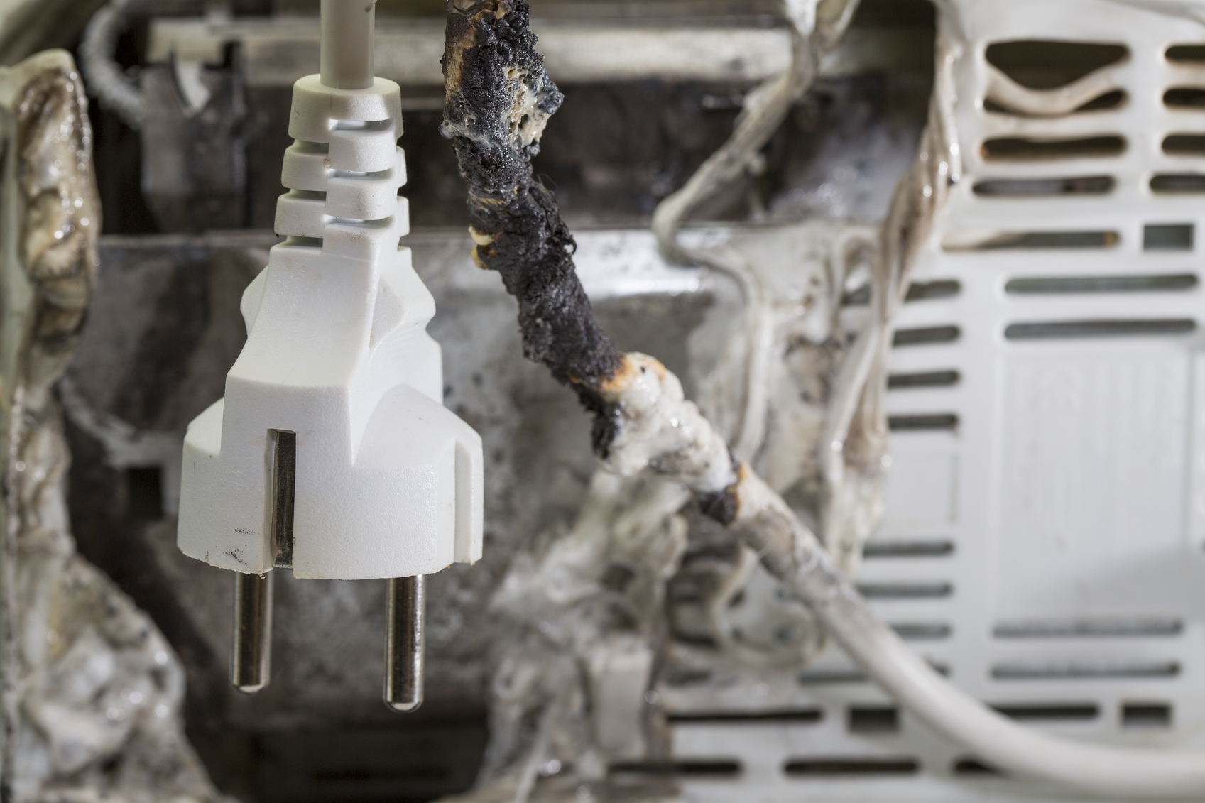 Closeup of burnt cable with burnt electrical appliance
